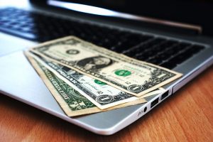 Dollar bills on a laptop.